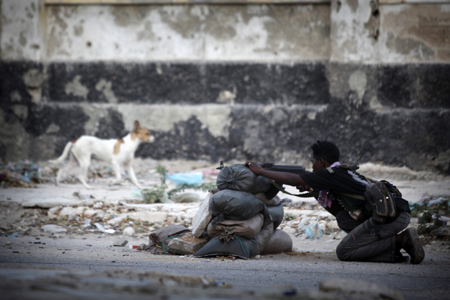 © Ed Ou / Reportage by Getty Images pour The New York Times Prix du Jeune Reporter de la ville de Perpignan 2011 #31. Mogadiscio, Somalie, 4 janvier 2010. Sur la ligne de front, un soldat de 14 ans défend le Gouvernement fédéral de transition contre les insurgés d’Al-Shabab vers le carrefour K4.