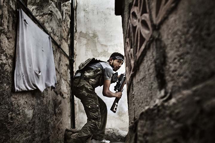 Un combattant de l'Armée syrienne libre prend position dans le quartier Halabi Suleiman, un bastion des rebelles, lors d'affrontements avec les forces gouvernementales. A Free Syrian Army fighter takes up position in the Sulemain Halabi district, a rebel stronghold, during clashes with government forces.