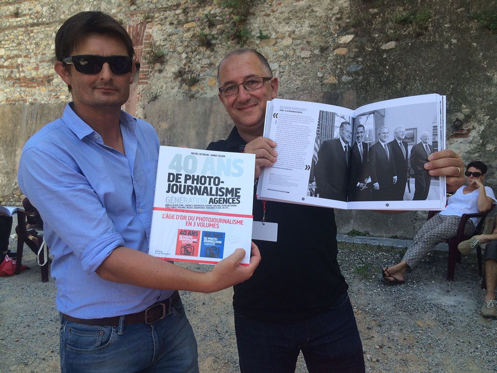 Jean-Michel Psaila avec le photographe Olivier Douliery accrédité à la Maison Blanche pour Abaca montrant une parution dans le livre "Génération Agences" Ed La Matinières © Abaca